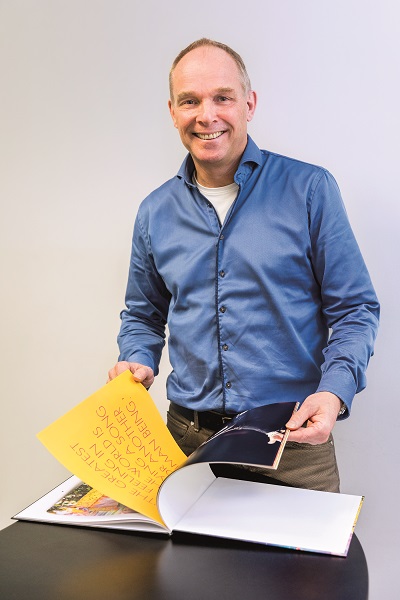 Paul Adriaans met het boek over de afscheidstournee van Elton John 